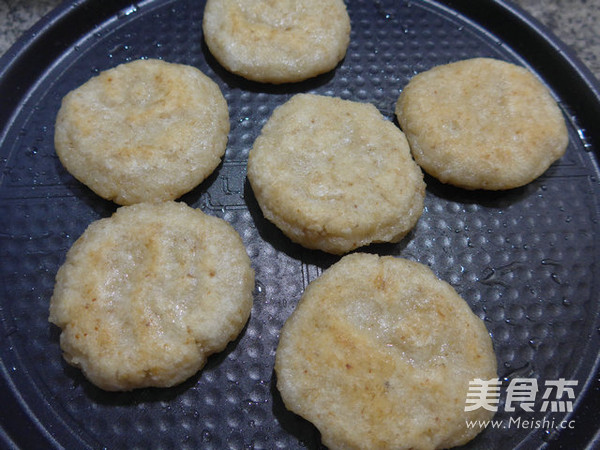 然后,在电饼铛中加4汤勺油,放入做好的燕麦片糯米饼的生坯煎至两面金