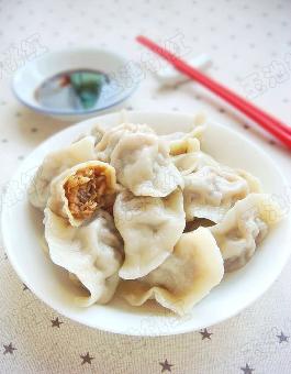 4.)取出馅料放在水饺皮中间,沾水黏合包成饺子状. 5.
