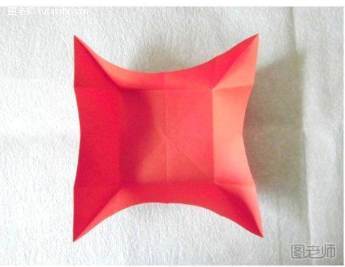 步骤5:然后按照前面制作好的折痕，将折纸模型的四个边向折纸模型的中间部分进行聚拢操作，将正方形四角捏起来，效果如图所示