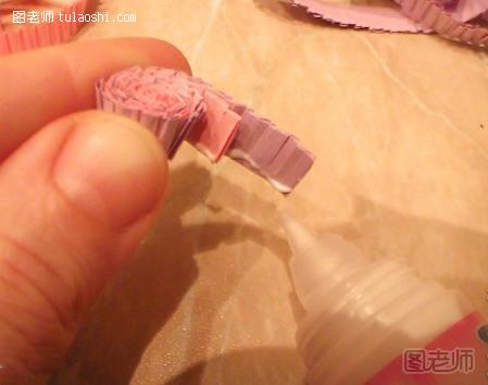 步骤4:缠绕的长度根据自己的需要而定，不过最终玫瑰紫色的瓦楞纸要稍微长一些，然后在她们的基部涂抹上白胶