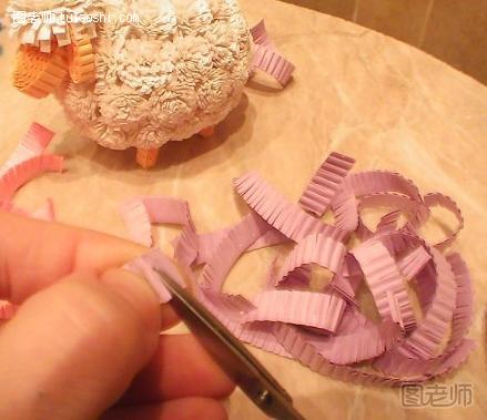 步骤2:用剪刀将瓦楞纸的边缘剪裁成絮状，剪裁的深度为0.7厘米，这里的制作很像是一些衍纸花的制作