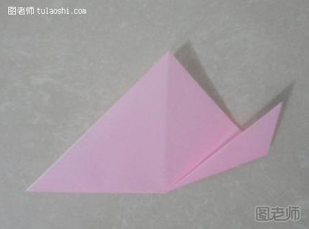 步骤18:如图所示，折痕把三角形分成了两个小三角形。把右边三角形的角对齐中间线往上折