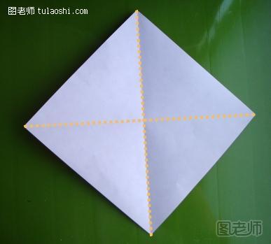 步骤2:将纸张翻到白色的一面。然后如图所示的先将两队对角线上的两个角进行对折，然后展开之后在纸张的中间留下两条对角线的折痕，即如图所示的折痕。这些折痕将辅助后面折纸圣诞老人的制作。