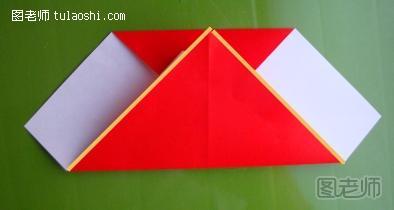 步骤7:接着将折纸模型的底角向上翻折，翻折的落点是在整个折纸模型的顶边上面，具体操作和落点可以参考折纸图示中的位置。