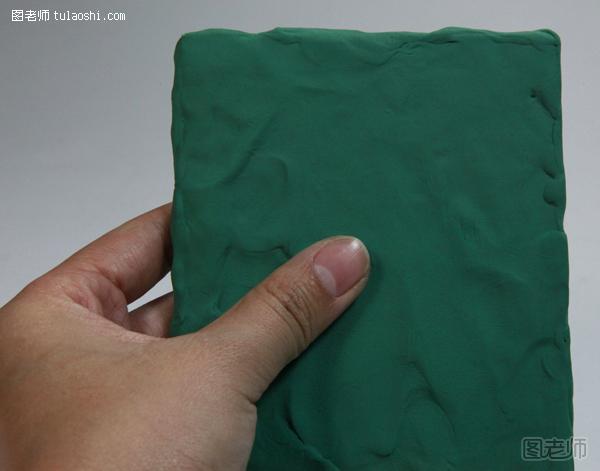 步骤1:准备一块长方形kt板，然后取一大块深绿色黏土，在kt板上推开