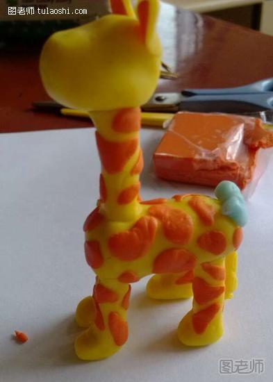 步骤10:给长颈鹿捏一身花纹 ，随意用橙色软陶捏