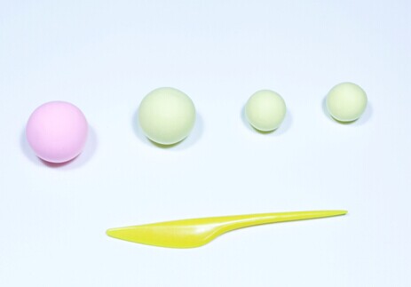 过程1:用粉色粘土制作一个圆球，作为月饼的草莓馅儿。用浅黄色粘土制作一个大圆球和两个小圆球，作为月饼的面儿。