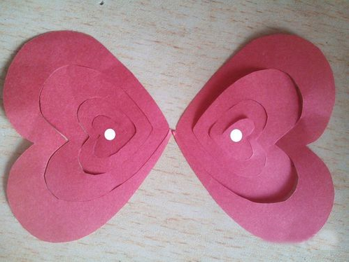 过程6:两个爱心桃剪下来后，把两张纸中心的爱心桃用胶水粘起来，图中白色圆点处粘在一同