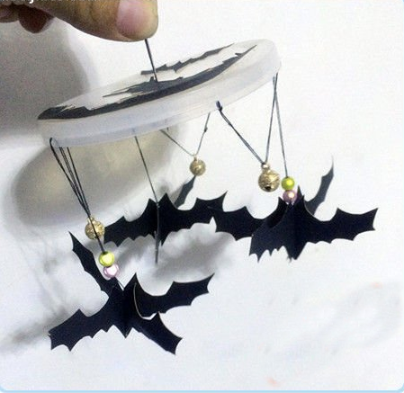 13.相同的办法再串两组蝙蝠上去，两两中间的位置可以缝上铃铛做装饰，再在塑料盖中心位置串一根线作提手，万圣节道具制作蝙蝠风铃完成~
