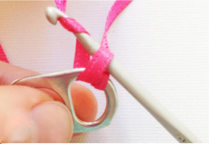 步骤4:再把钩针钩住拉环后的长端丝带