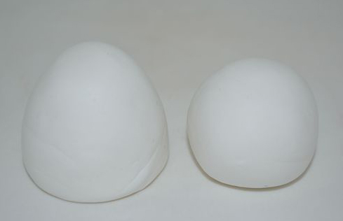 STEP1：首先搓两块一大一小的白色球状和椭圆状的橡皮泥，用作雪人的头部和身体。